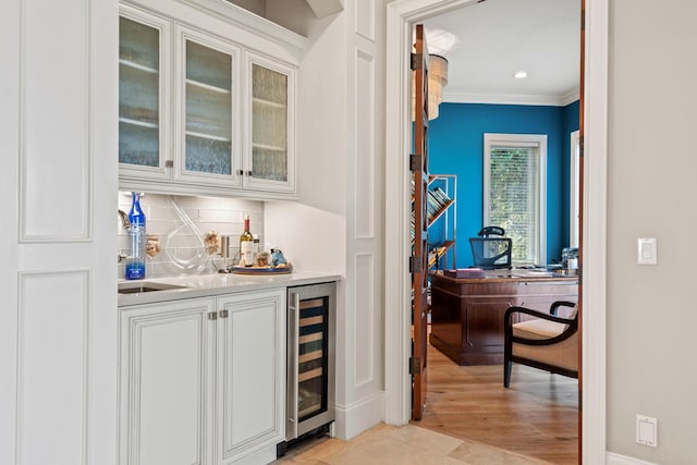 bar featuring wine cooler, tasteful backsplash, and white cabinetry