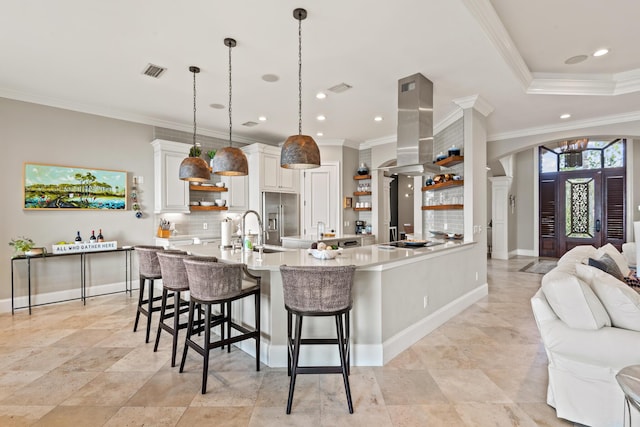 kitchen with pendant lighting, a kitchen bar, island exhaust hood, white cabinetry, and ornamental molding