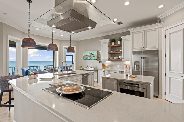 kitchen with a kitchen bar, white cabinetry, sink, hanging light fixtures, and a water view