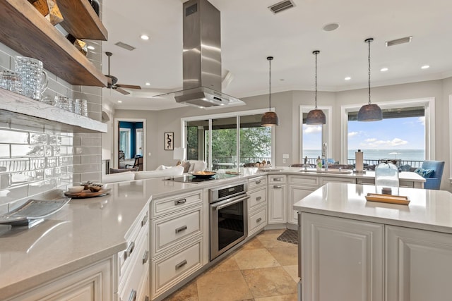 kitchen with white cabinetry, island range hood, black electric stovetop, stainless steel oven, and decorative light fixtures