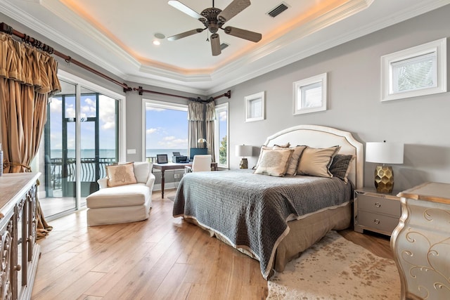 bedroom featuring light hardwood / wood-style floors, ceiling fan, access to outside, a tray ceiling, and ornamental molding