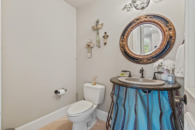 bathroom with toilet, tile patterned floors, and vanity