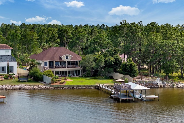 view of dock featuring a balcony, a yard, and a water view