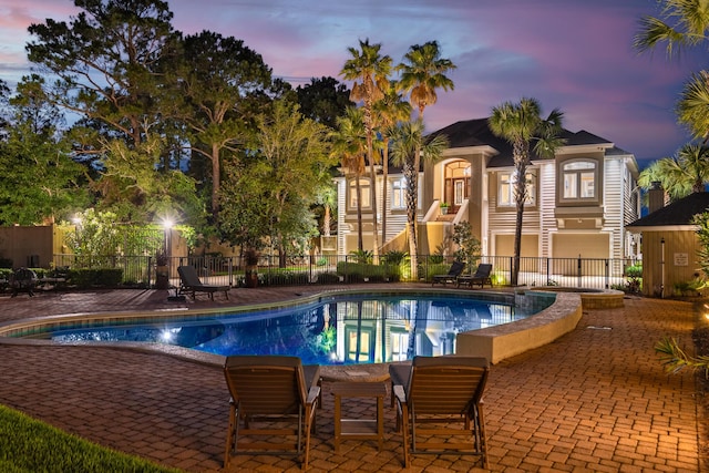 pool at dusk with a patio