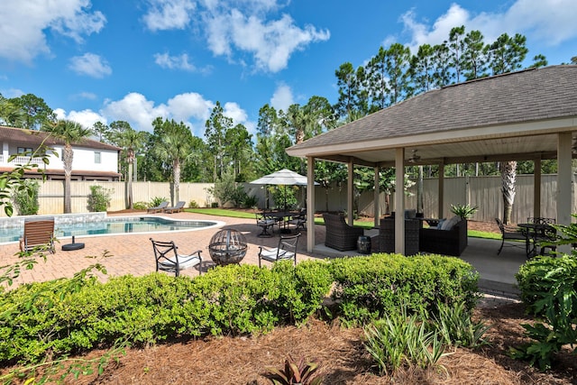 view of swimming pool with a gazebo, a patio, and an outdoor living space with a fire pit