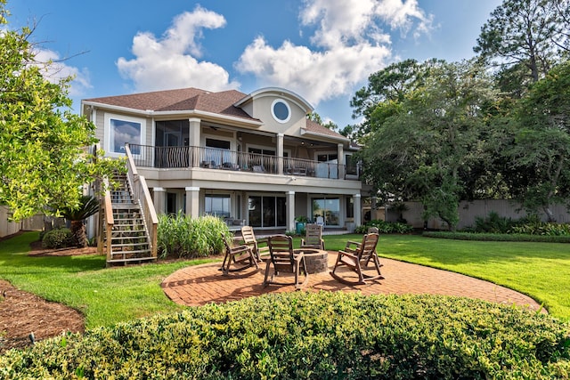 rear view of house featuring a patio area, a balcony, a fire pit, and a lawn