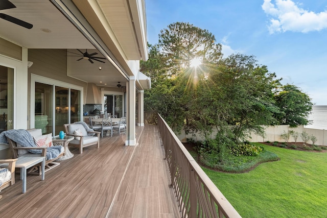 deck featuring ceiling fan and a yard