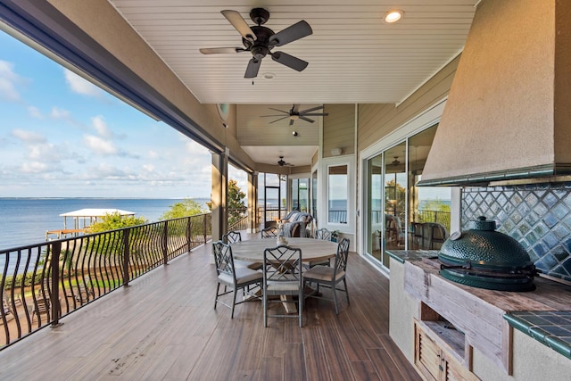 deck featuring ceiling fan and a water view