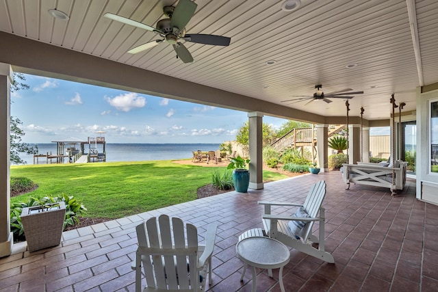 view of patio / terrace with ceiling fan and a water view