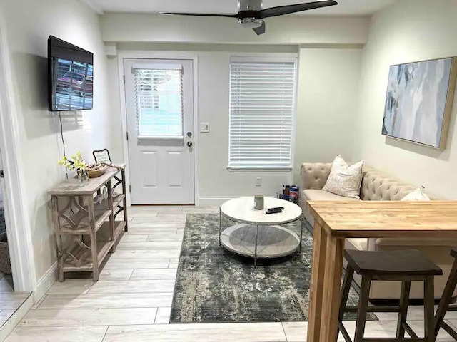 living room with light wood-type flooring and ceiling fan