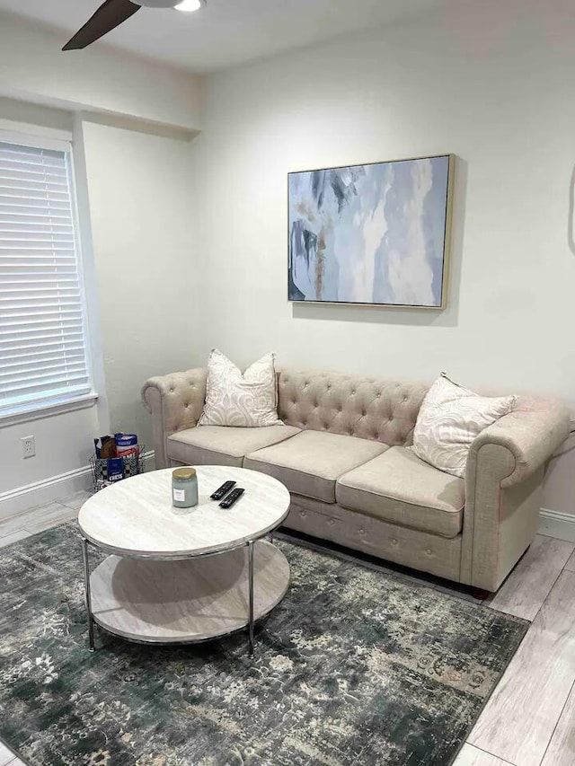 living room featuring wood-type flooring and ceiling fan