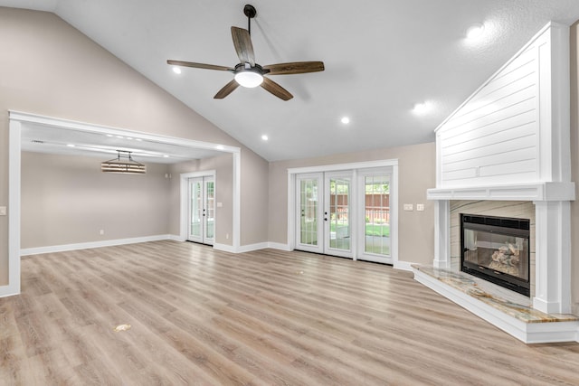 unfurnished living room with plenty of natural light, ceiling fan, light wood-type flooring, and a fireplace