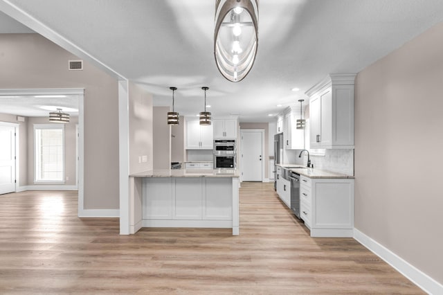 kitchen with backsplash, sink, appliances with stainless steel finishes, white cabinetry, and kitchen peninsula