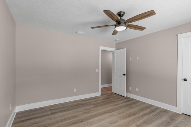 unfurnished bedroom featuring a textured ceiling, light hardwood / wood-style floors, and ceiling fan