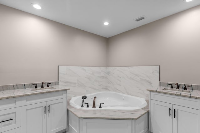 bathroom with vanity and a tub