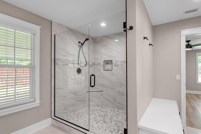 bathroom with ceiling fan and an enclosed shower