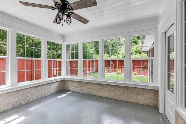 unfurnished sunroom featuring ceiling fan and a wealth of natural light