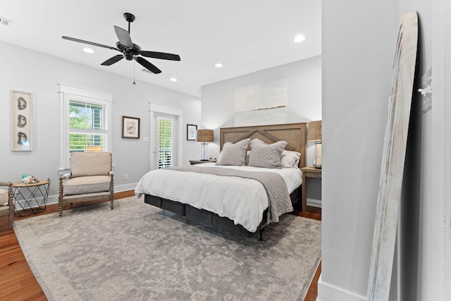 bedroom with wood finished floors, visible vents, baseboards, recessed lighting, and access to exterior