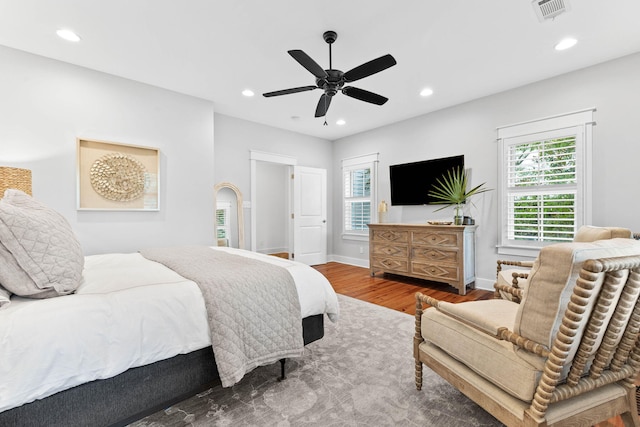 bedroom featuring visible vents, a ceiling fan, wood finished floors, recessed lighting, and baseboards