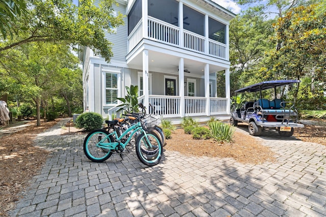 view of front of home with covered porch, a balcony, and a ceiling fan