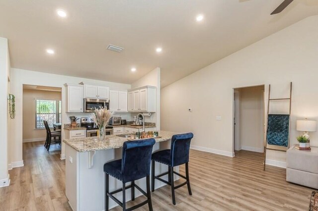 kitchen featuring light hardwood / wood-style flooring, stainless steel appliances, light stone counters, sink, and white cabinets