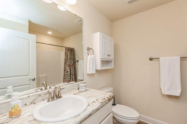 bathroom featuring large vanity and toilet