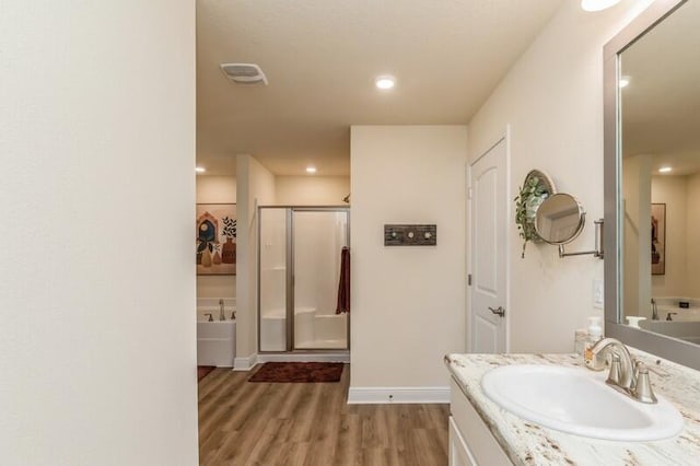 6022 Willsey Trl, Crestview, FL 32539 - full bathroom featuring vanity, wood finished floors, baseboards, a shower stall, and a bath