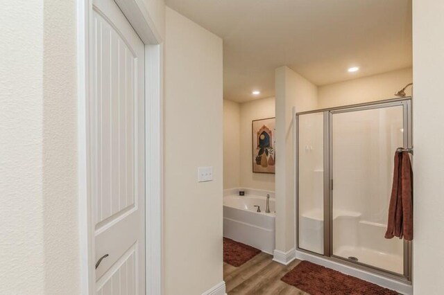 bathroom with wood-type flooring and independent shower and bath