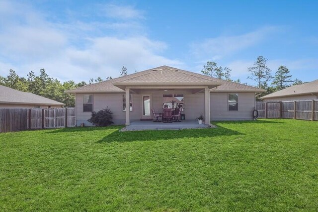 back of house with a patio and a yard