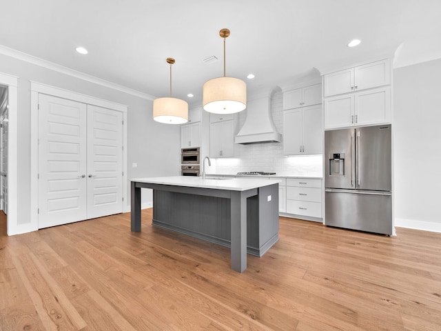 kitchen featuring white cabinets, custom exhaust hood, stainless steel appliances, and hanging light fixtures