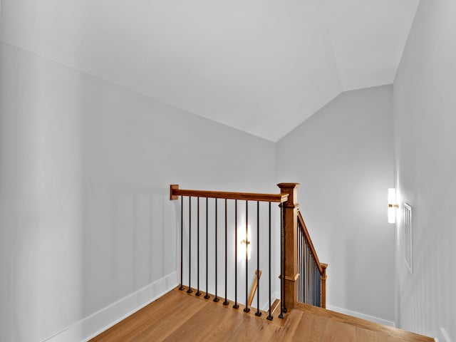 stairs with wood-type flooring and vaulted ceiling