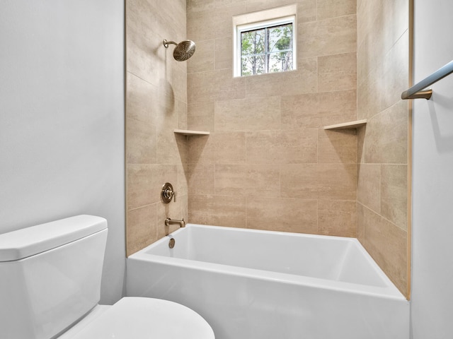 bathroom featuring tiled shower / bath combo and toilet