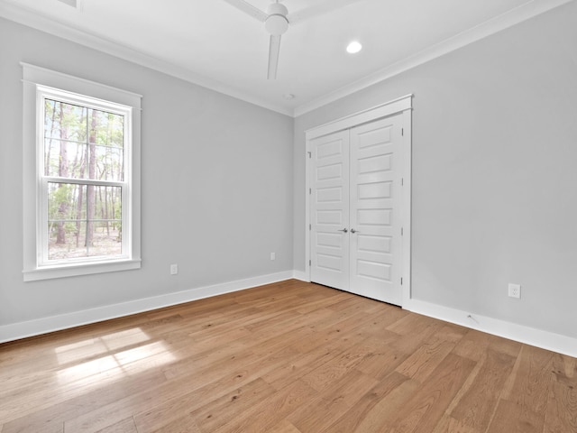 unfurnished bedroom with light hardwood / wood-style floors, ornamental molding, ceiling fan, and a closet