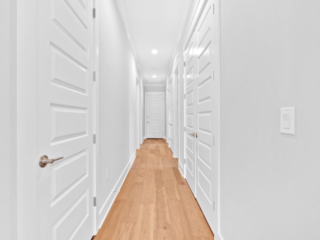 corridor with crown molding and light hardwood / wood-style floors