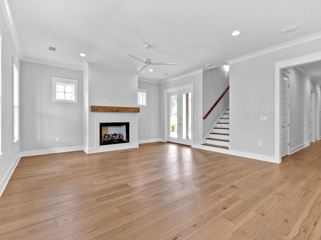 unfurnished living room featuring ceiling fan, a multi sided fireplace, plenty of natural light, and light hardwood / wood-style flooring