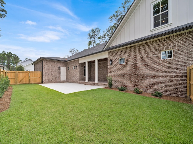 rear view of property with a lawn and a patio area