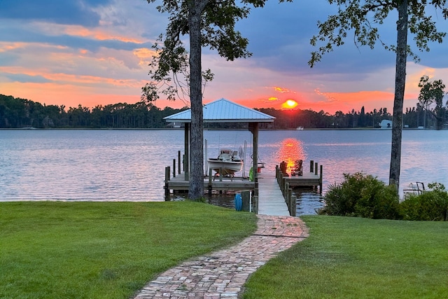 dock area with a lawn, a water view, and boat lift