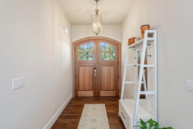 doorway to outside with baseboards, arched walkways, dark wood-style floors, an inviting chandelier, and french doors