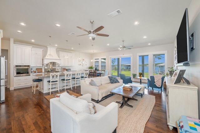 living room featuring dark wood finished floors, visible vents, and recessed lighting