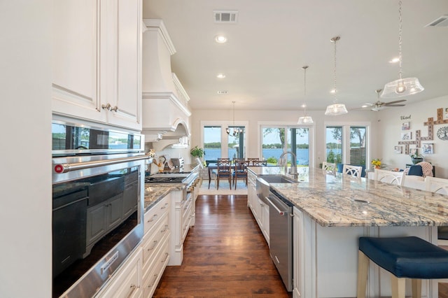 kitchen with white cabinets, a spacious island, a kitchen bar, and stainless steel appliances