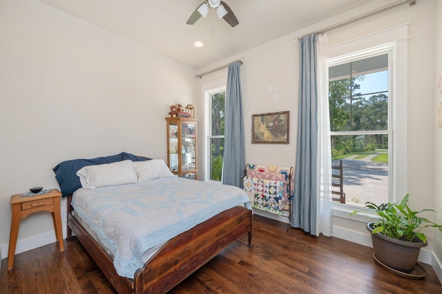 bedroom with a ceiling fan, multiple windows, baseboards, and dark wood-style flooring