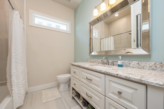 full bathroom with toilet, vanity, and baseboards