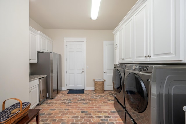 laundry area with brick floor, cabinet space, baseboards, and separate washer and dryer