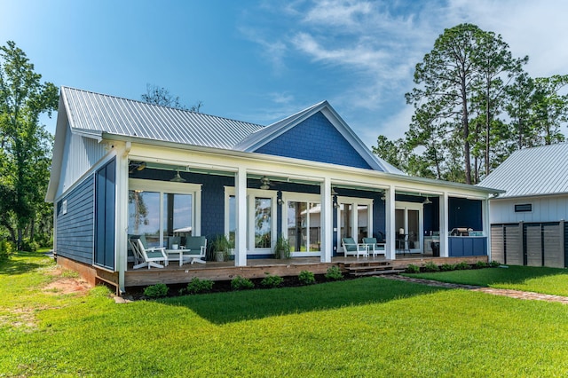 rear view of house featuring metal roof, a yard, fence, and a sunroom