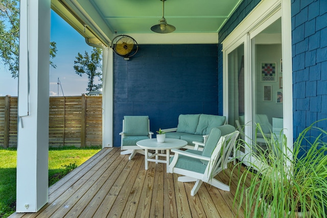 wooden terrace with a ceiling fan, fence, and an outdoor hangout area