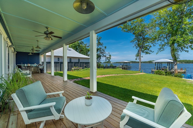 view of terrace featuring a deck with water view, ceiling fan, and a dock