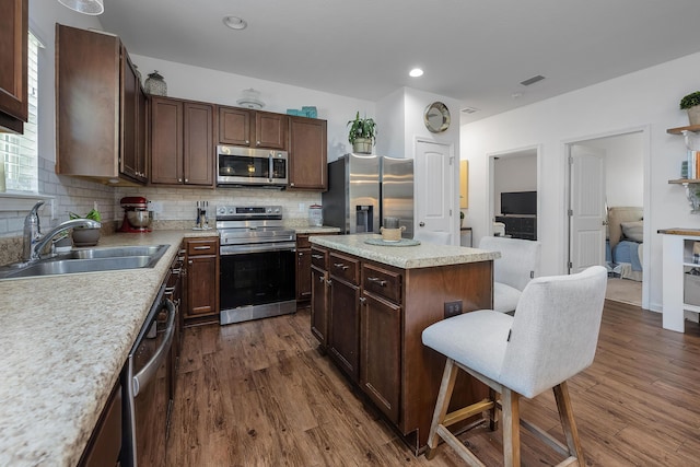 kitchen featuring tasteful backsplash, sink, a center island, and stainless steel appliances