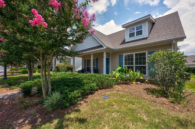 view of front of home with covered porch and a front yard