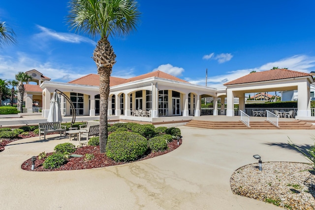 back of house with a sunroom, a patio area, and a gazebo