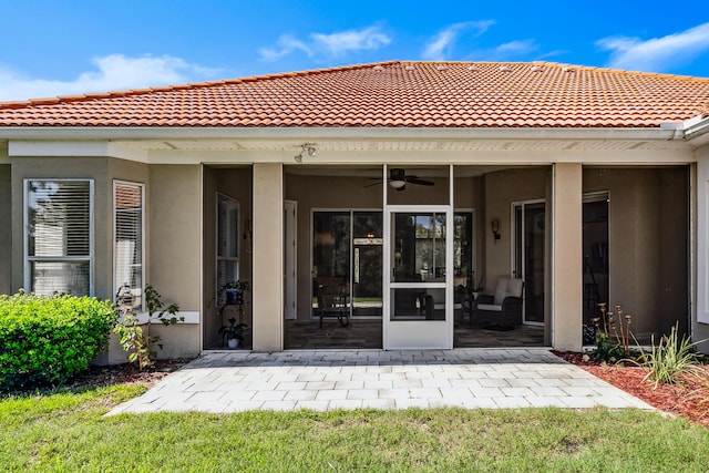 rear view of house featuring a sunroom and stucco siding